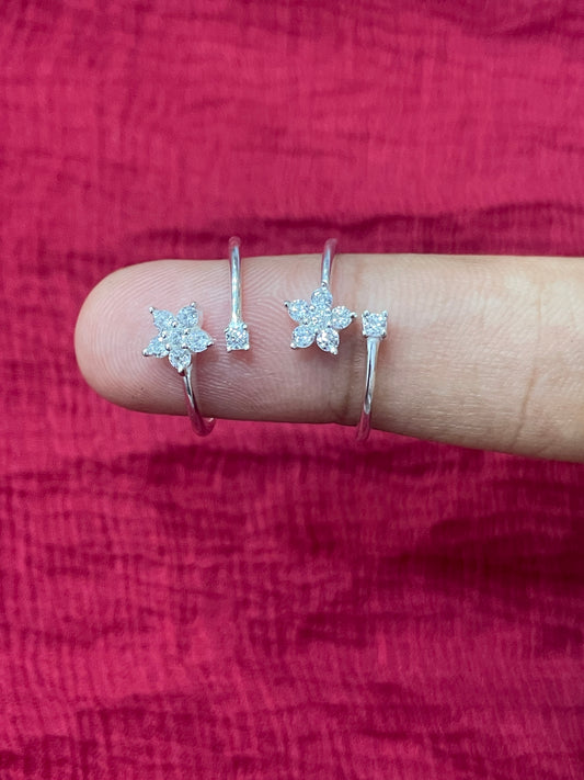 Close-up of a hand wearing two silver star-shaped rings on a red fabric background