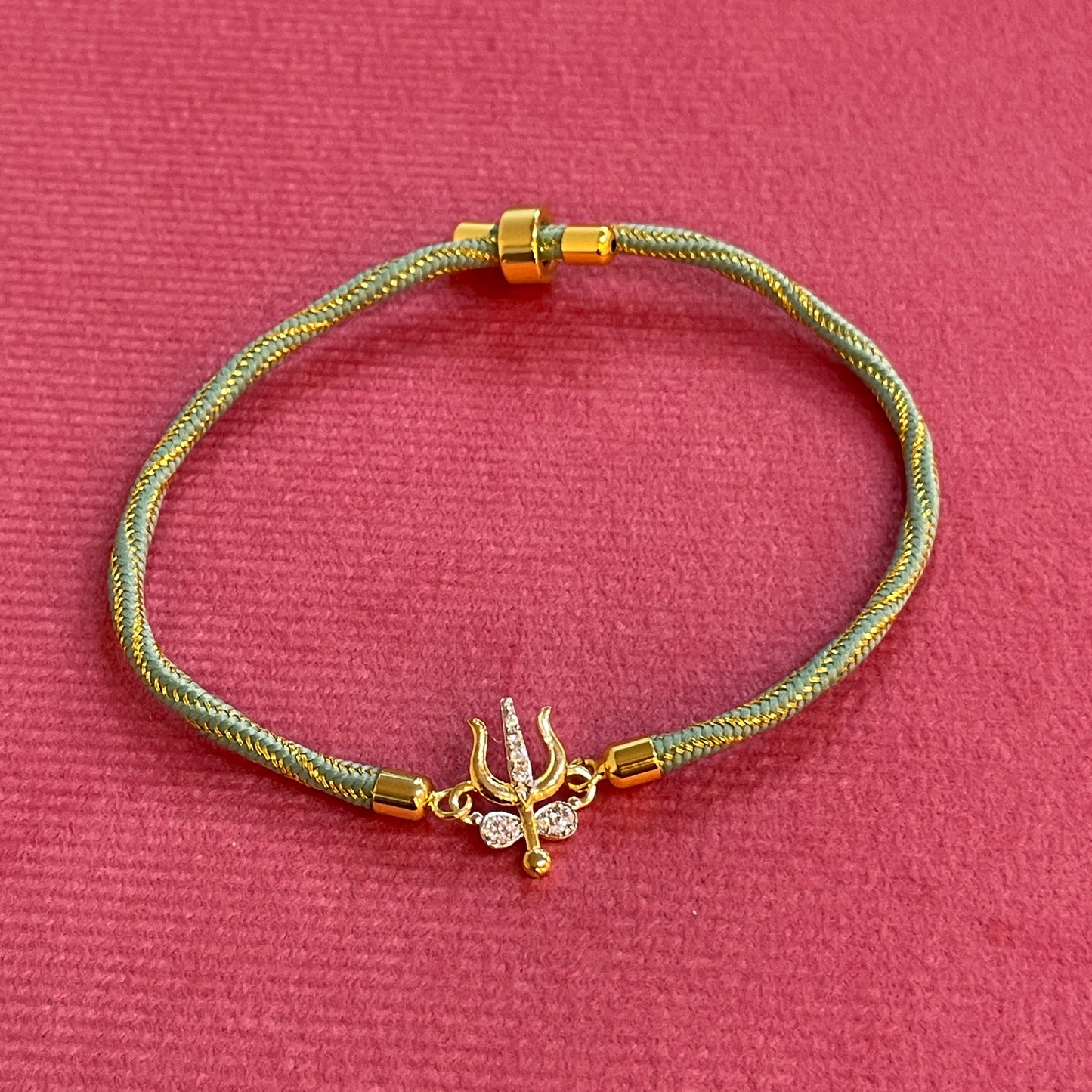 Silver Trishul Rakhi for Brother | Gold Plated Trishul Charm with CZ Stones on Mint Green Thread