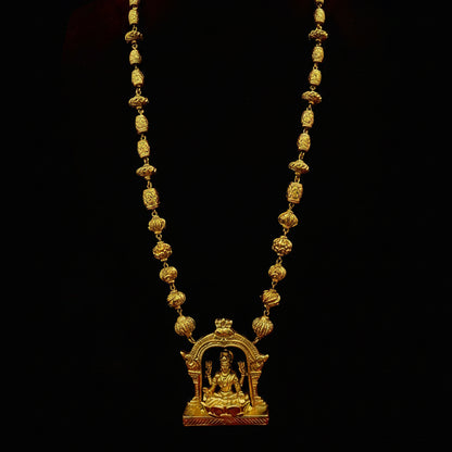 Gold necklace with a decorative pendant on a red fabric background