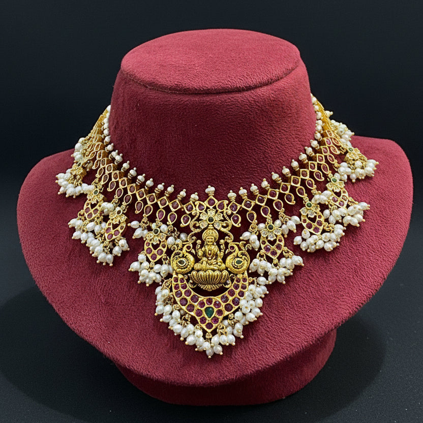 Gold and pearl necklace on a red fabric background