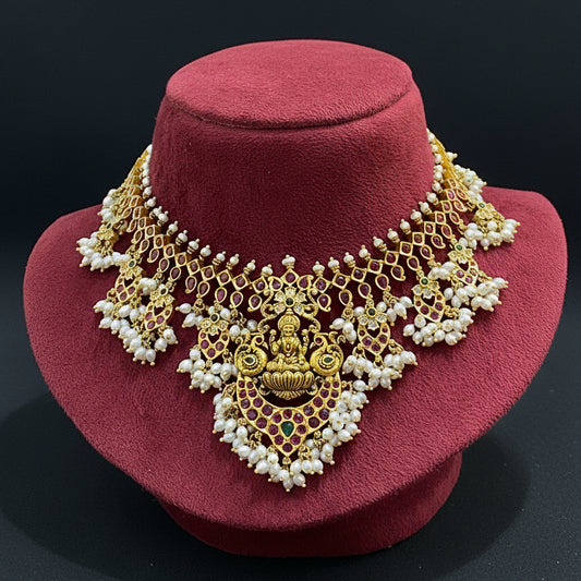 Gold and pearl necklace on a red fabric background