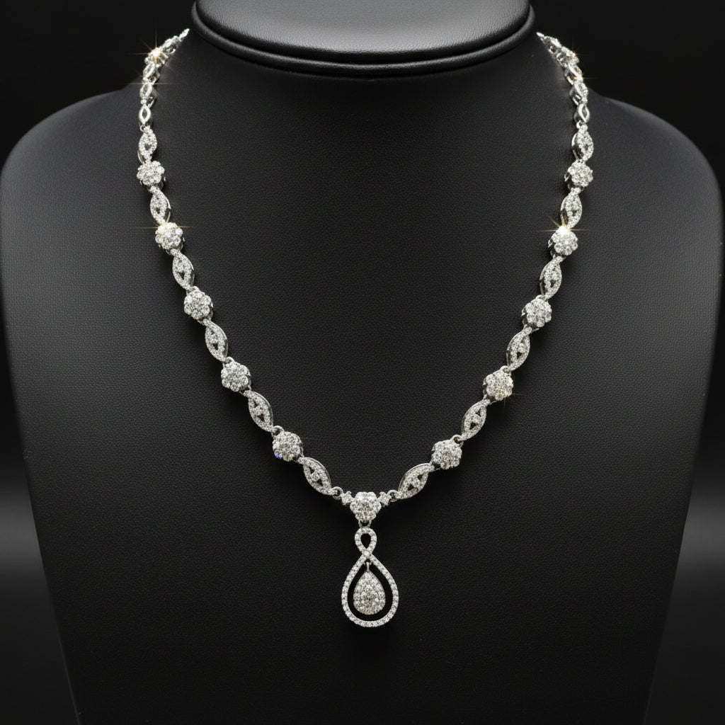 Silver necklace with a teardrop pendant on a red fabric background