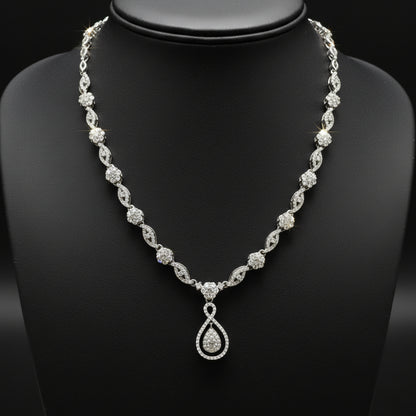 Silver necklace with a teardrop pendant on a red fabric background