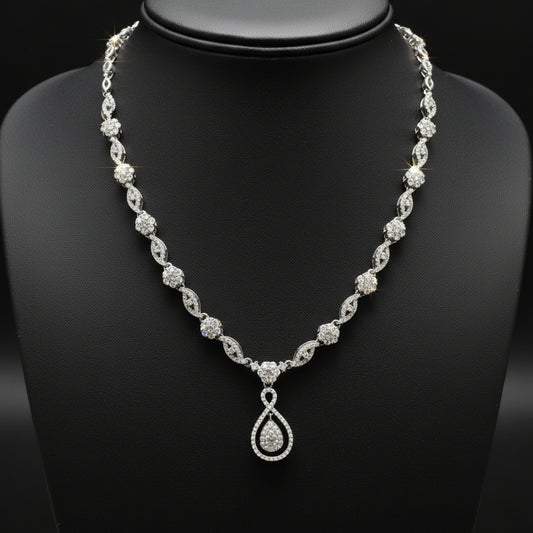 Silver necklace with a teardrop pendant on a red fabric background