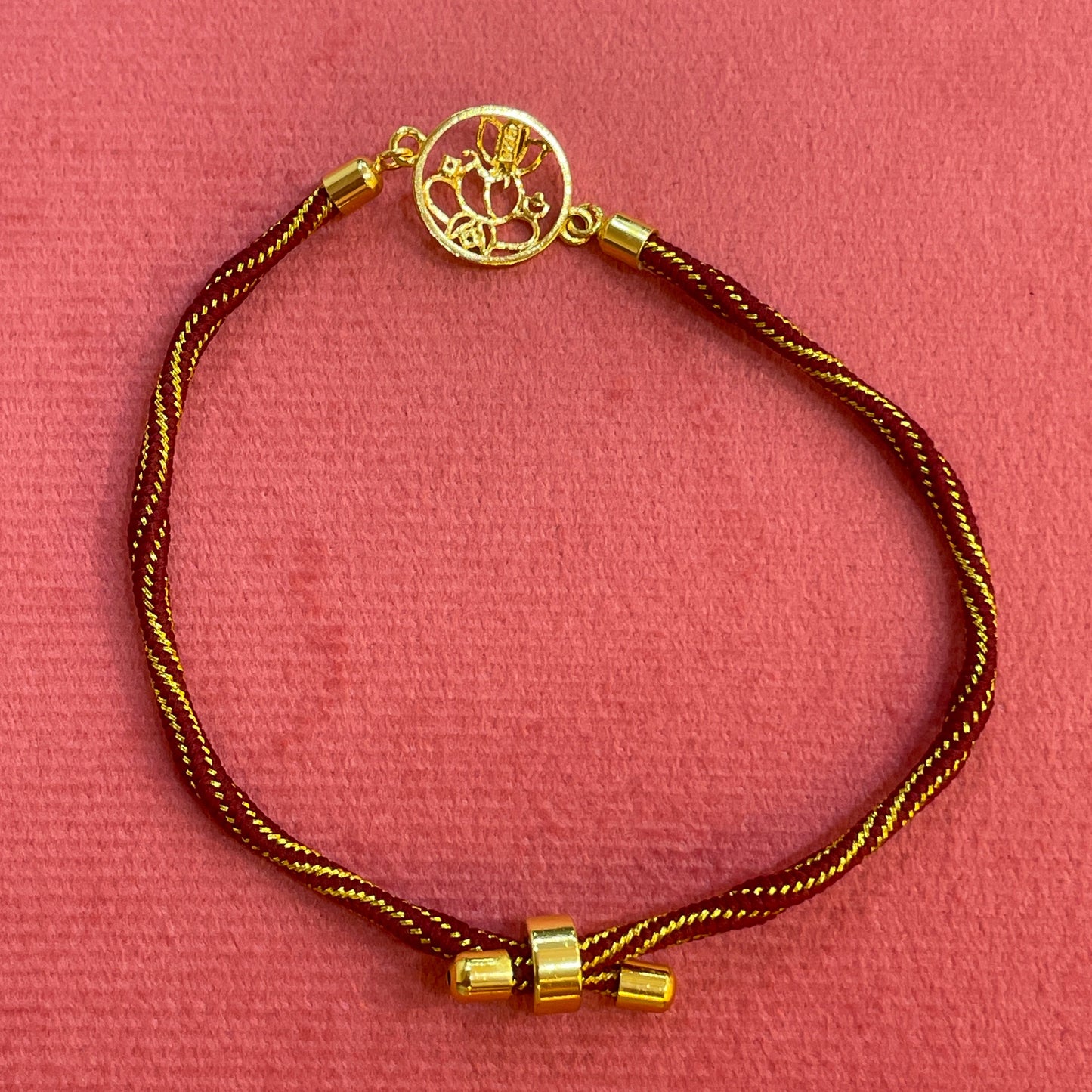 Gold Plated Ganesha Rakhi for Brother | Circular Cutwork Motif with Maroon Thread