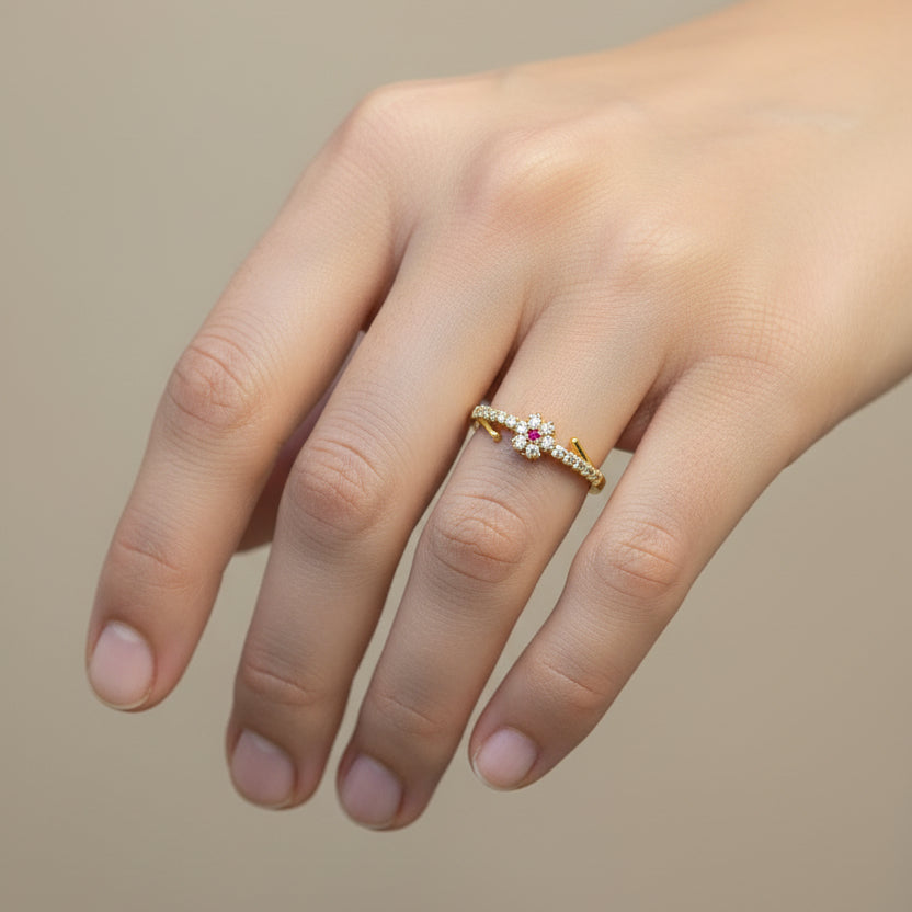 Gold ring with gemstones on a finger against a red fabric background