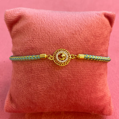 Silver Om Rakhi for Brother | Gold Plated CZ Charm with Teal Thread