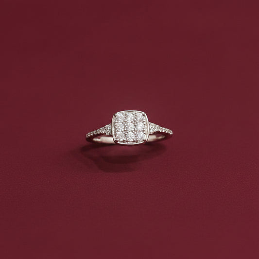 Diamond ring on a teal fabric background with red fabric partially covering it