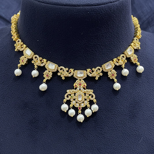 Gold and pearl jewelry set on a red fabric background