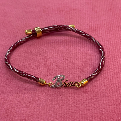 Gold-Plated Bhaiya Name Rakhi for Brother | CZ Script Charm on Maroon & Gold Twisted Thread
