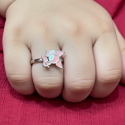 Hand wearing a butterfly-themed ring on a pink fabric background