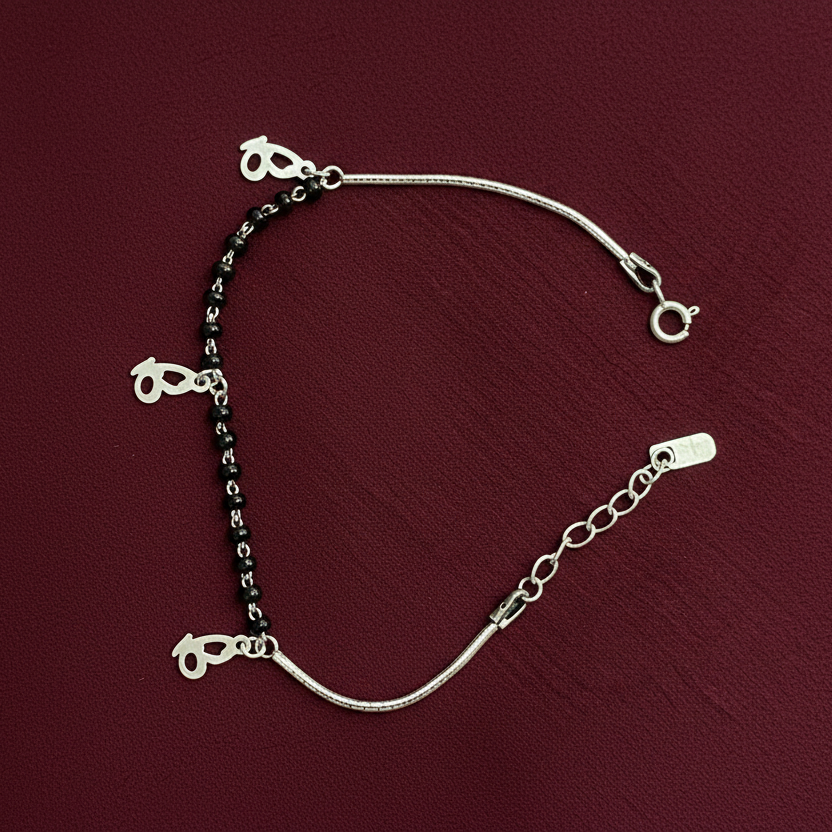 Silver bracelet with heart-shaped charms on a red fabric background
