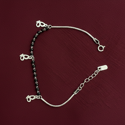 Silver bracelet with heart-shaped charms on a red fabric background