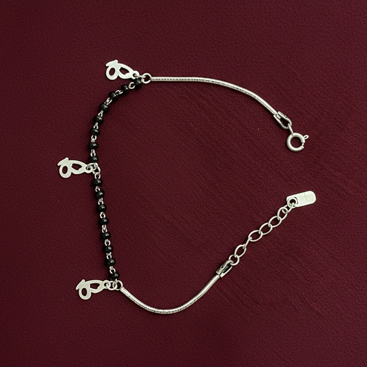 Silver bracelet with heart-shaped charms on a red fabric background