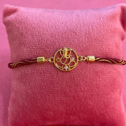Gold Plated Ganesha Rakhi for Brother | Circular Cutwork Motif with Maroon Thread
