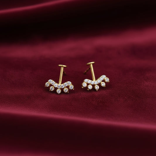 Pair of gold plated on silver bugadi earrings with gemstones on a maroon background