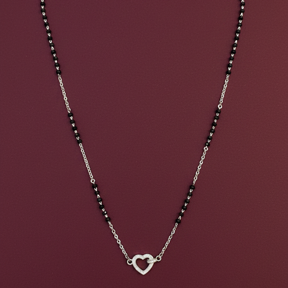 Silver necklace with heart clasp on a red fabric background