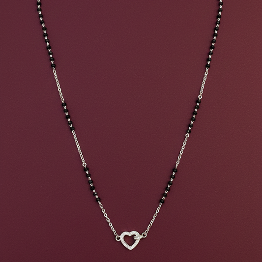 Silver necklace with heart clasp on a red fabric background