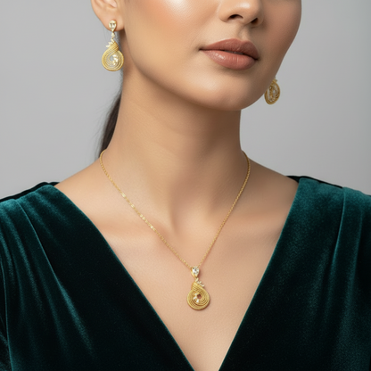 Woman wearing gold jewelry including earrings and a necklace against a gray background