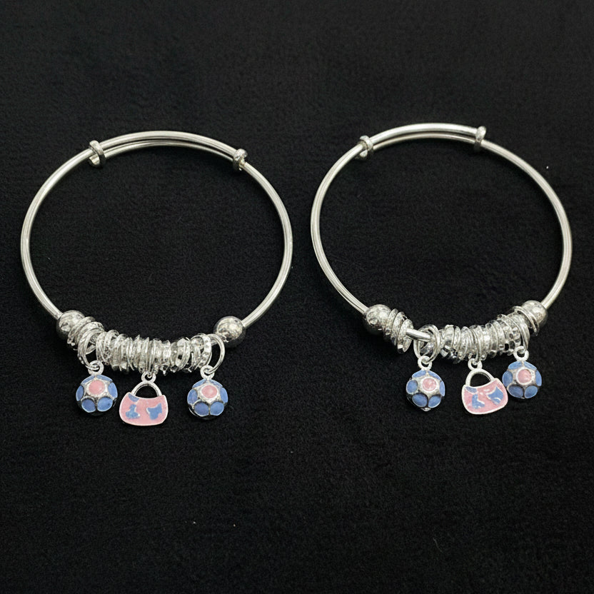 Two silver hoop earrings with heart-shaped charms on a teal background