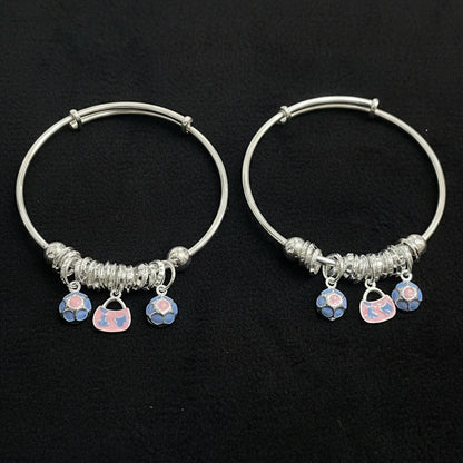 Two silver hoop earrings with heart-shaped charms on a teal background