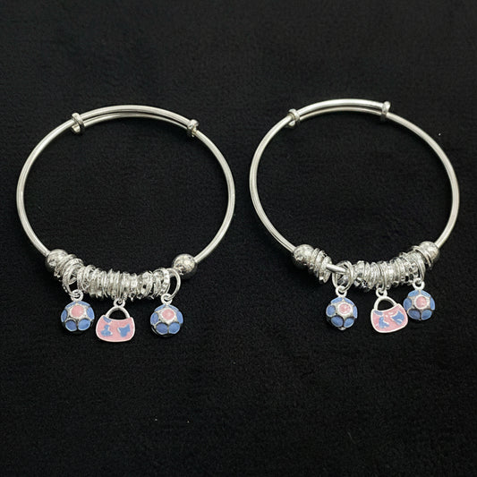 Two silver hoop earrings with heart-shaped charms on a teal background