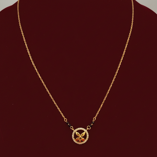 Gold necklace with a decorative pendant on a red fabric background