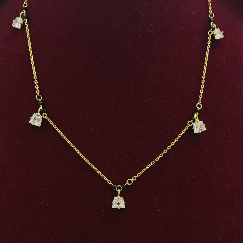 Gold necklace with diamond-like pendants on a red background