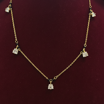 Gold necklace with diamond-like pendants on a red background