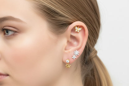 Close-up of a woman's ear wearing floral earrings with a neutral background