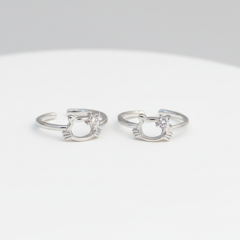 Pair of silver cat-shaped rings on a white background