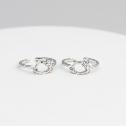 Pair of silver cat-shaped rings on a white background