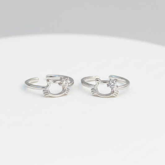 Pair of silver cat-shaped rings on a white background