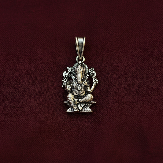 Silver pendant with intricate design on a maroon background