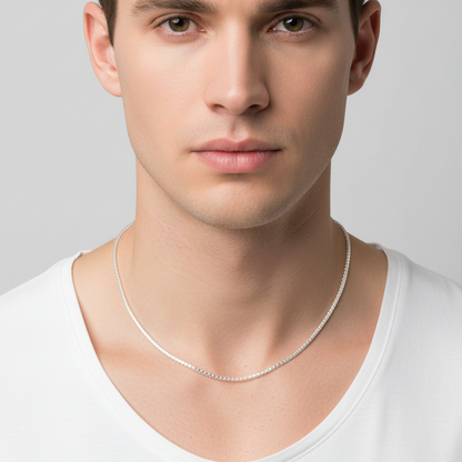 Man wearing a silver necklace against a plain background