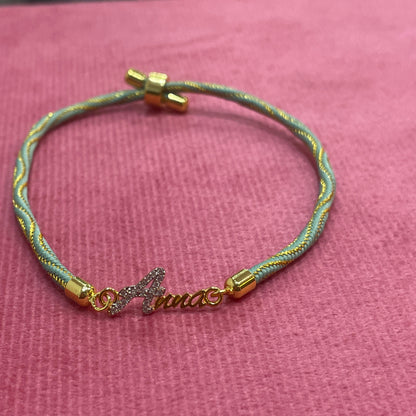 Gold-Plated Name Rakhi for Brother | CZ Script Charm on Teal & Gold Twisted Thread