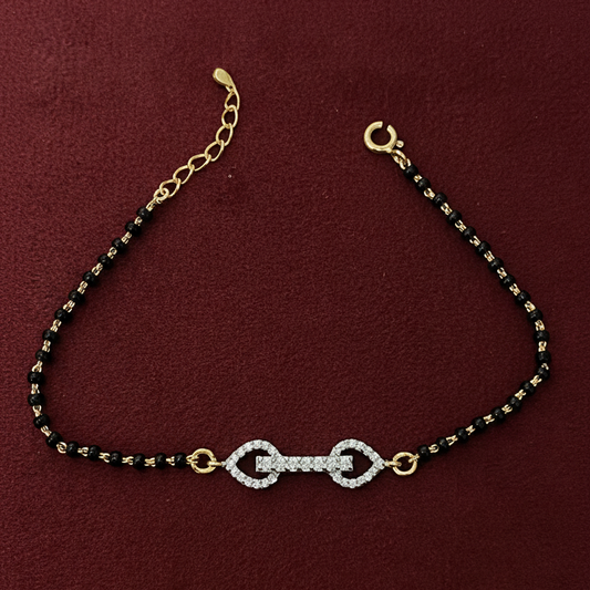 Bracelet with black beads and gold accents on a red background