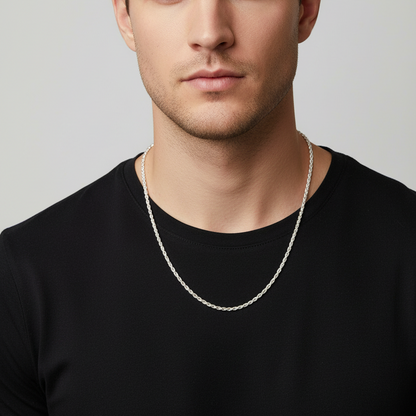 Man wearing a black shirt and silver necklace against a light gray background