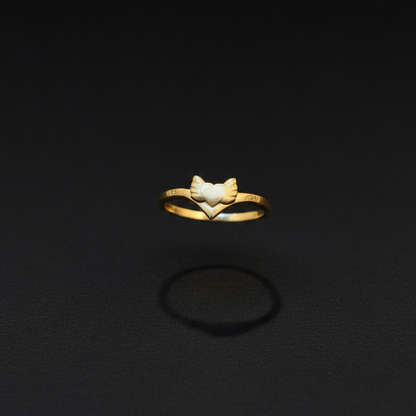 Gold ring with a leaf design on a finger against a red fabric background