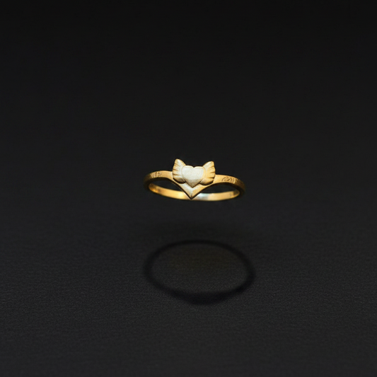 Gold ring with a leaf design on a finger against a red fabric background