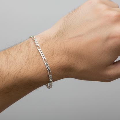 Silver bracelet on a wrist against a gray background