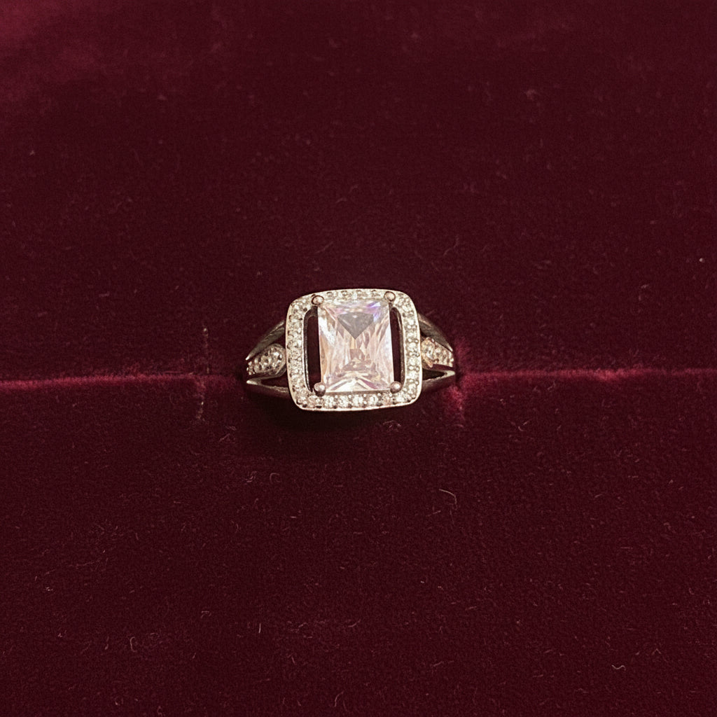 Diamond ring on a green fabric background with red fabric partially covering it