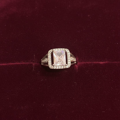 Diamond ring on a green fabric background with red fabric partially covering it