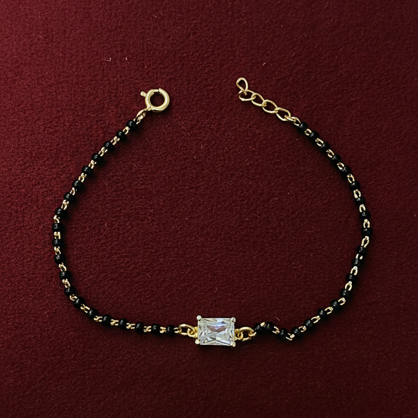 Bracelet with gold and black beads on a red background