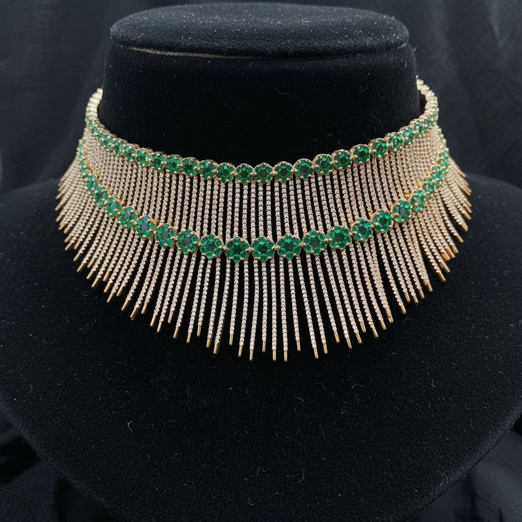 Gold and green gemstone necklace on a pink cushion