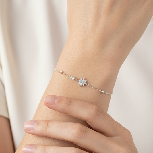 Silver bracelet with a star-shaped clasp on a red fabric background