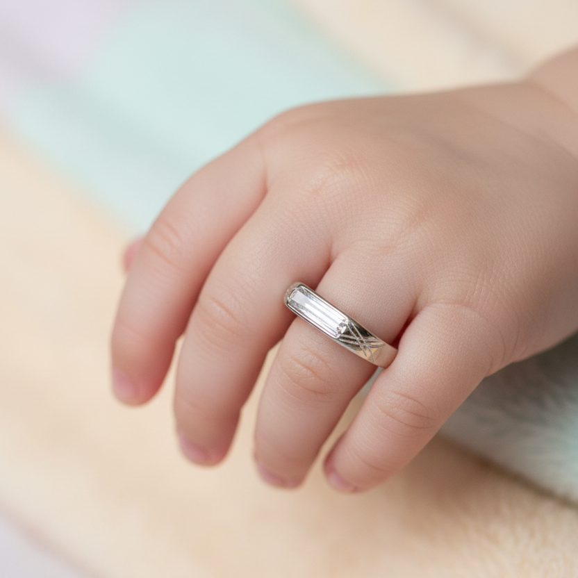 Close-up of a hand wearing a silver ring on a soft, blurred background