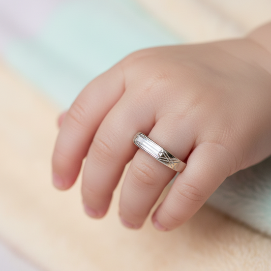 Close-up of a hand wearing a silver ring on a soft, blurred background