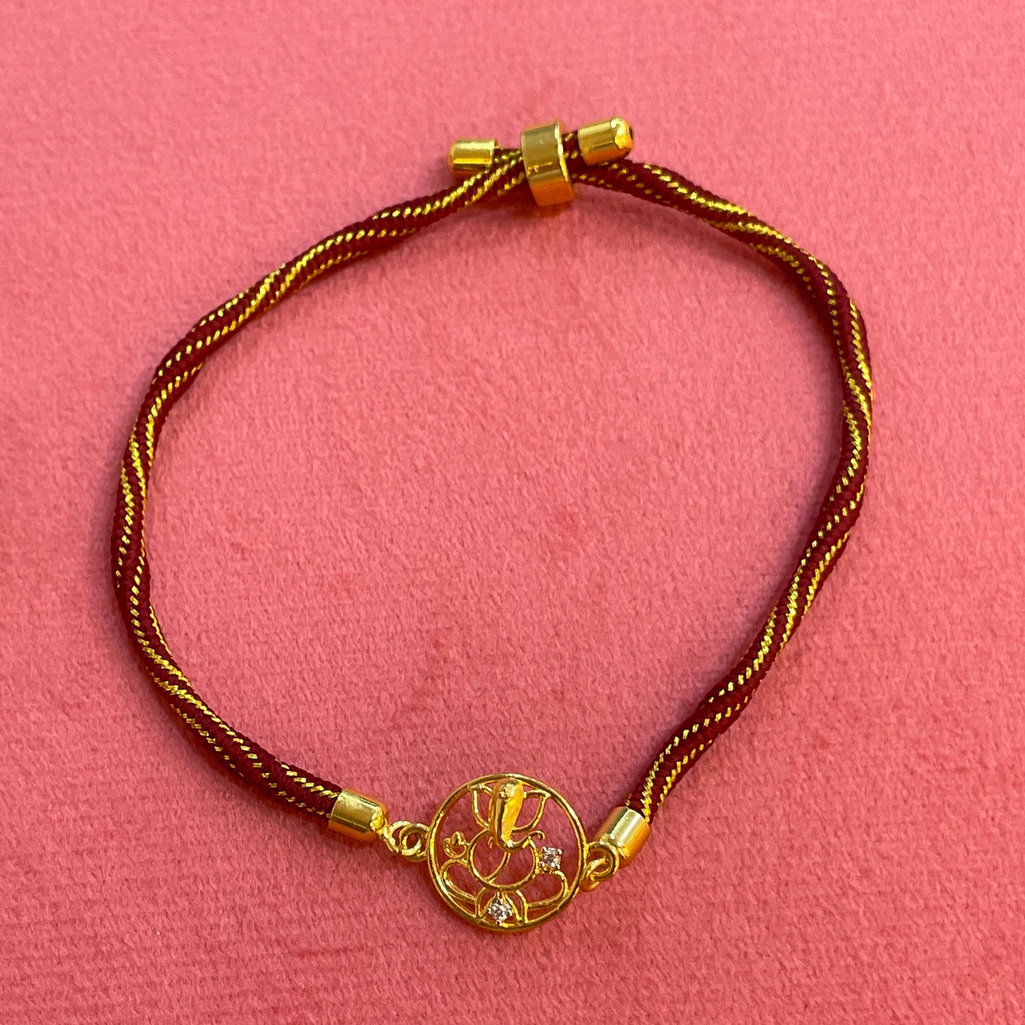 Gold Plated Ganesha Rakhi for Brother | Circular Cutwork Motif with Maroon Thread