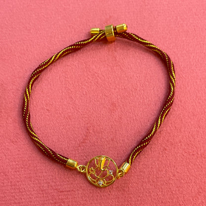 Gold Plated Ganesha Rakhi for Brother | Circular Cutwork Motif with Maroon Thread